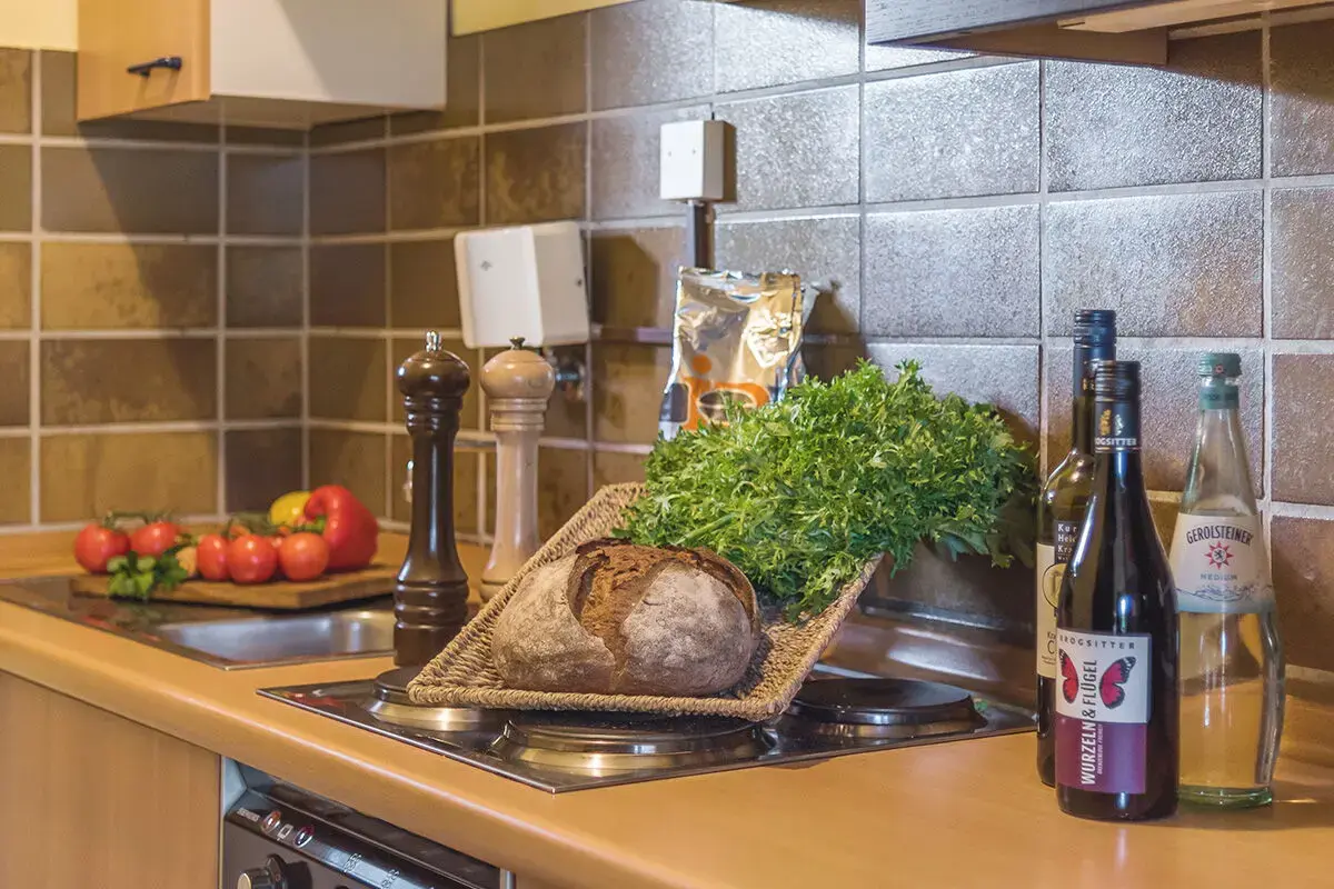 Küchenzeile mit frischem Gemüse, Brot und Getränken laden zum Kochen im Ferienhaus Kastanie ein