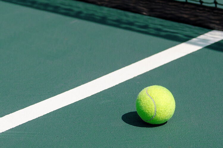 Tennisball liegt auf Tennisplatz im Sporthotel Grafenwald