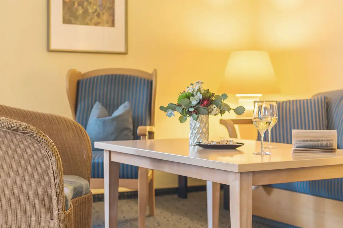 Sofaecke im Ferienhaus Kastanie mit Weingläsern und Buch