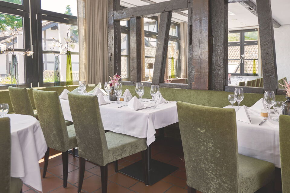 Mit Gläsern, Servierten und Besteck festlich gedeckte Tische im Restaurant Grafenwald