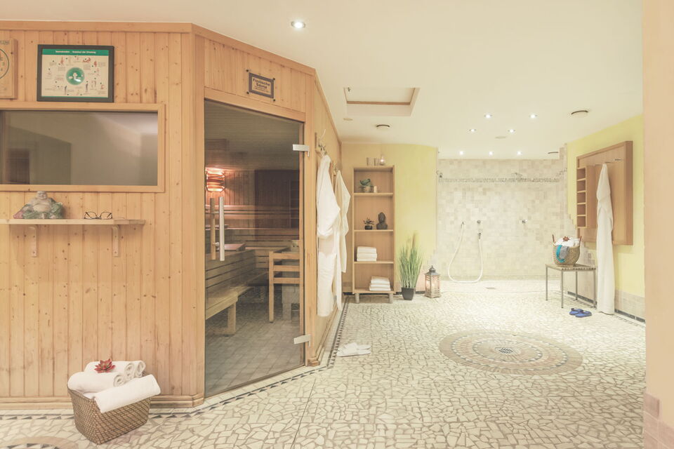 Schöne Saunalandschaft mit Sauna und Duschbereich im Sporthotel Grafenwald