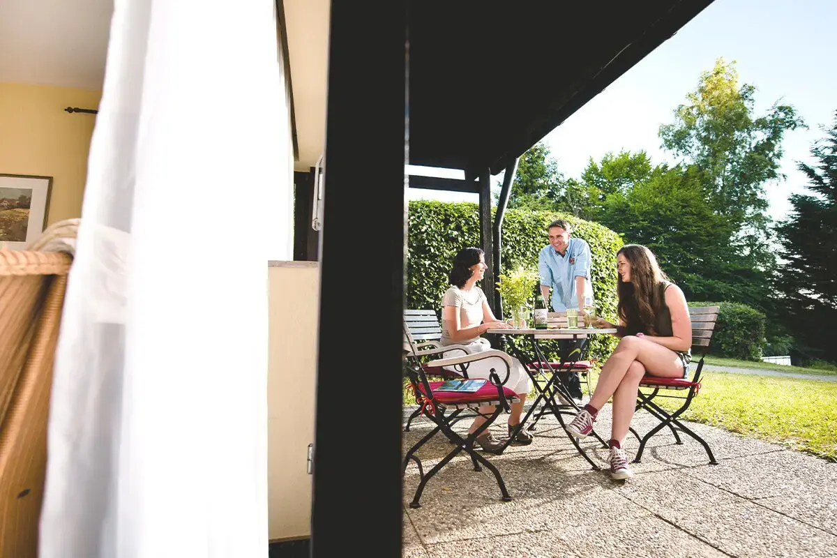 Familie sitzt gemütlich auf der Terrasse des Ferienhaus Ahorn