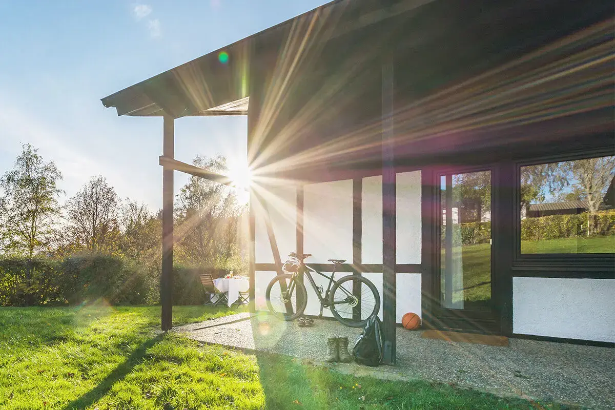 Terrasse des Ferienhaus Kastanie mit Fahrrad, Ball und Wanderschuhen