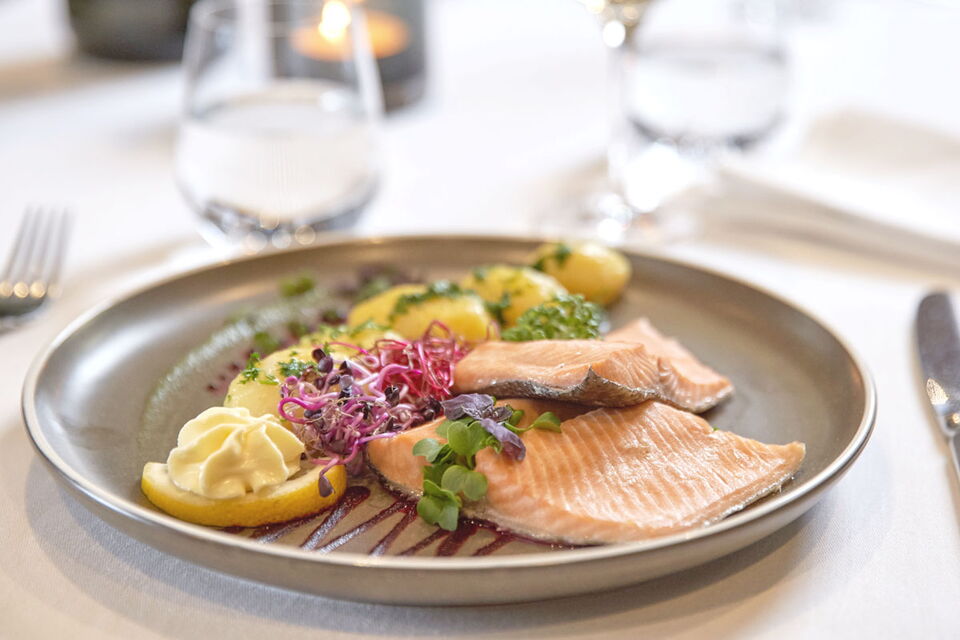 Geschmackvoll angerichteter Tisch mit einem Teller mit Fisch und Kartoffeln